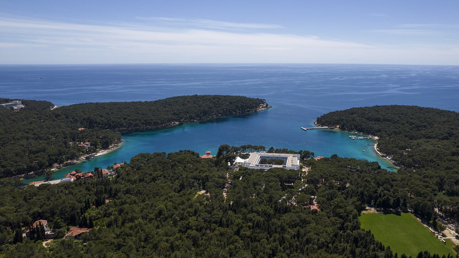 Pine-fringed Čikat Bay on Lošinj, with clear Adriatic water lapping the shore