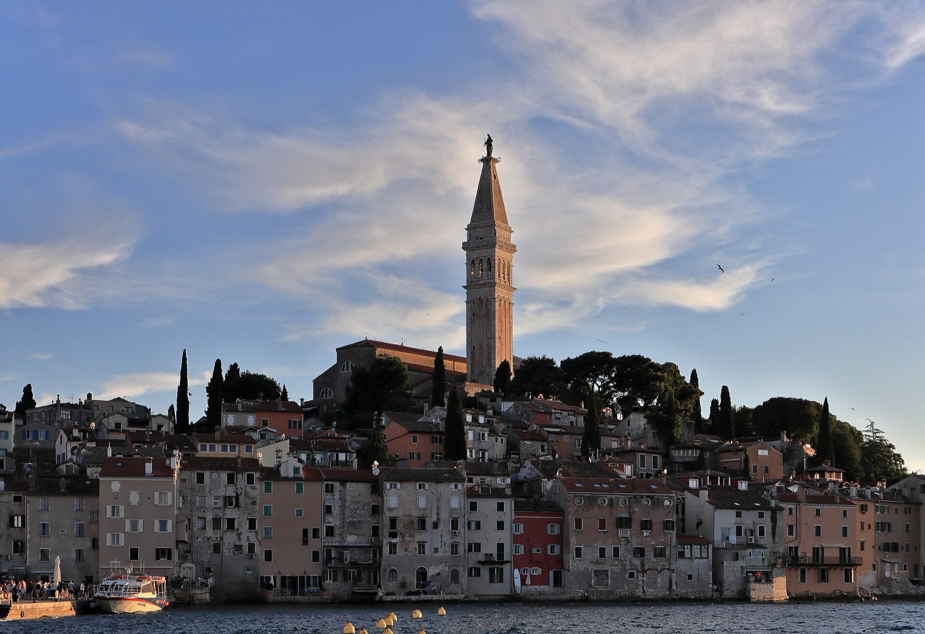 Rovinj's pastel harborfront houses seen from the water on a clear day